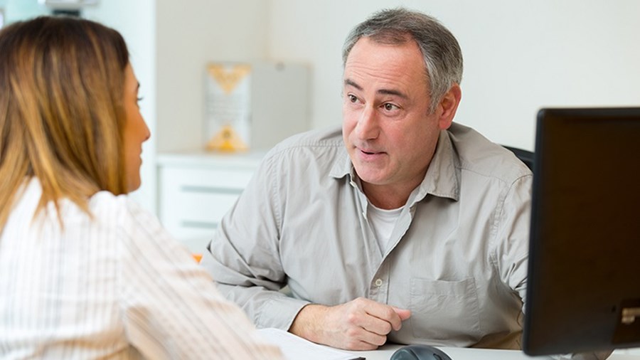 Man zit tegenover vrouw en voert gesprek.