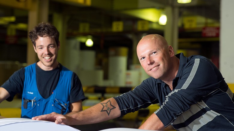 Twee mannen met rollen drukpapier