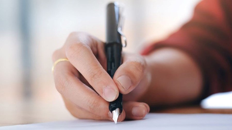 Hand schrijft met pen op papier