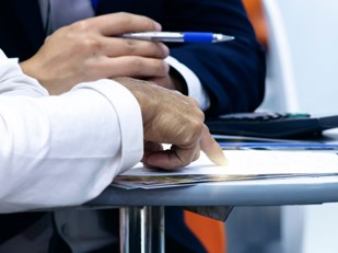 Mensen aan de onderhandelingstafel met pen en papier