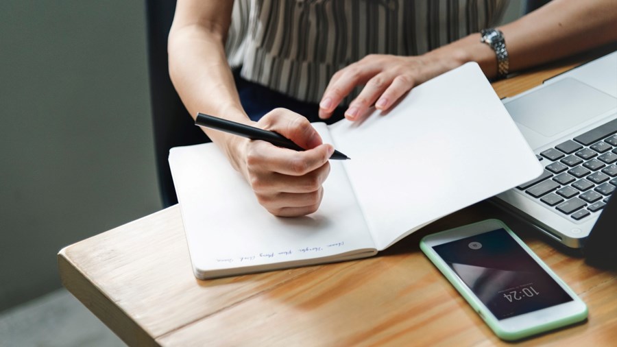 Vrouw die in notitieboekje schrijft