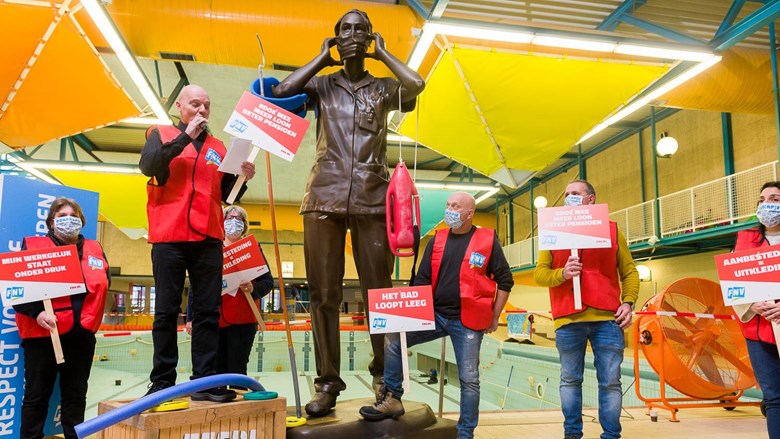 Zwembadmedewerkers met actiebordjes