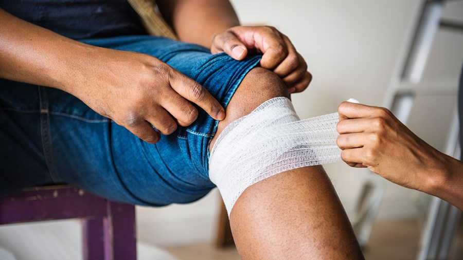 Een gewonde knie wordt in verband gewikkeld