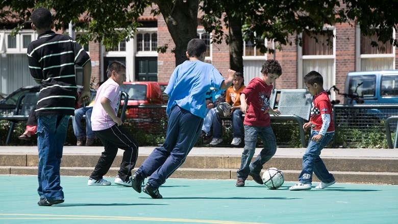 Kinderen spelen voetbal op een pleintje