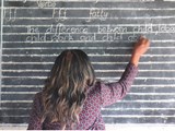 meisje schrijft op schoolbord "the difference between child labur, child work and child abuse.