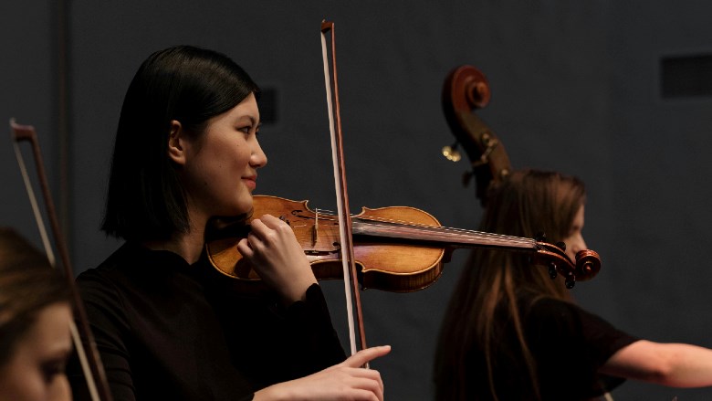 vrouw speelt viool in orkest