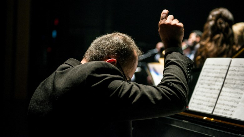 Man in kostuum speelt klassiek piano