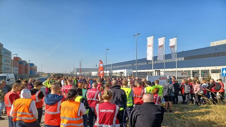 A group of people are standing in front of the H&M warehouse