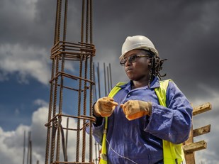 vrouw aan het werk op een bouwplaats in Rwanda