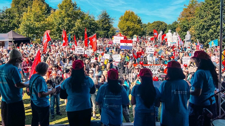 Foto vanaf het podium van een veld vol migrant workers
